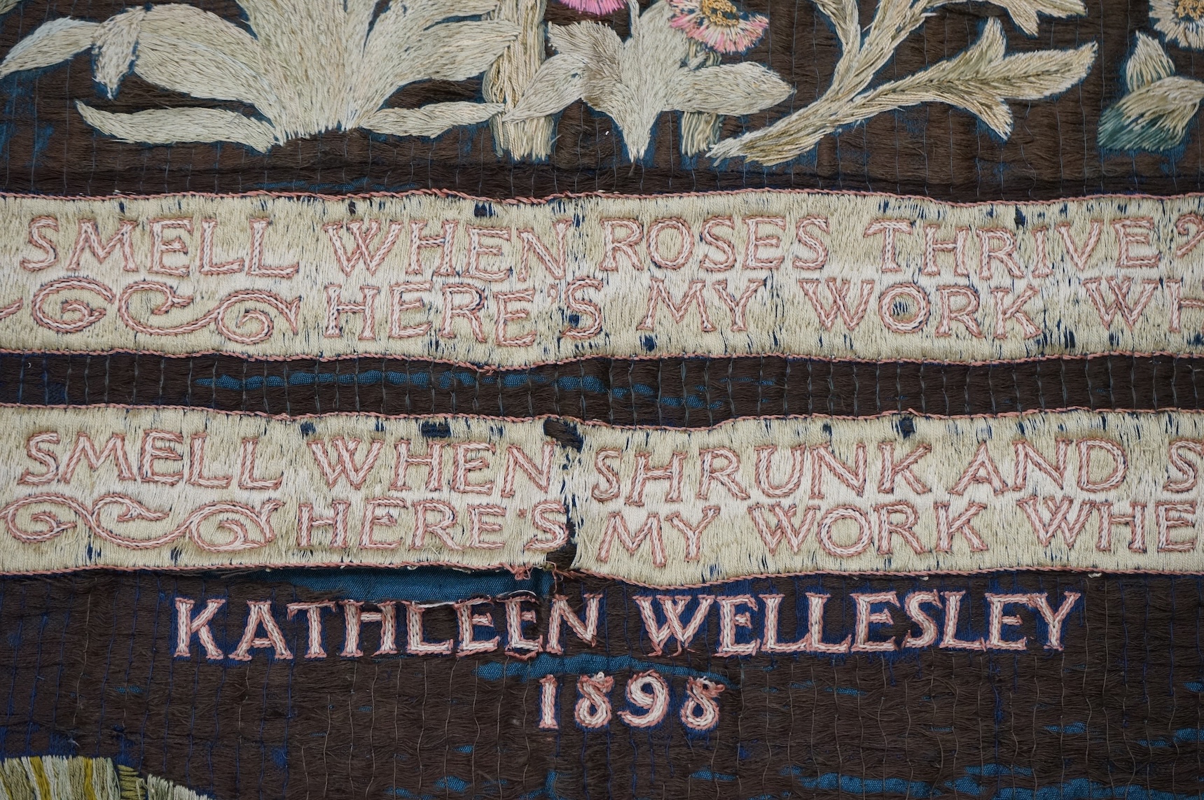 A large Arts and Crafts silk embroidered wall hanging, embroidered in the manner of May Morris with a large central scrolling flowering rose tree and banner embroidered with Salve and a two row motto below;, Rose leaves